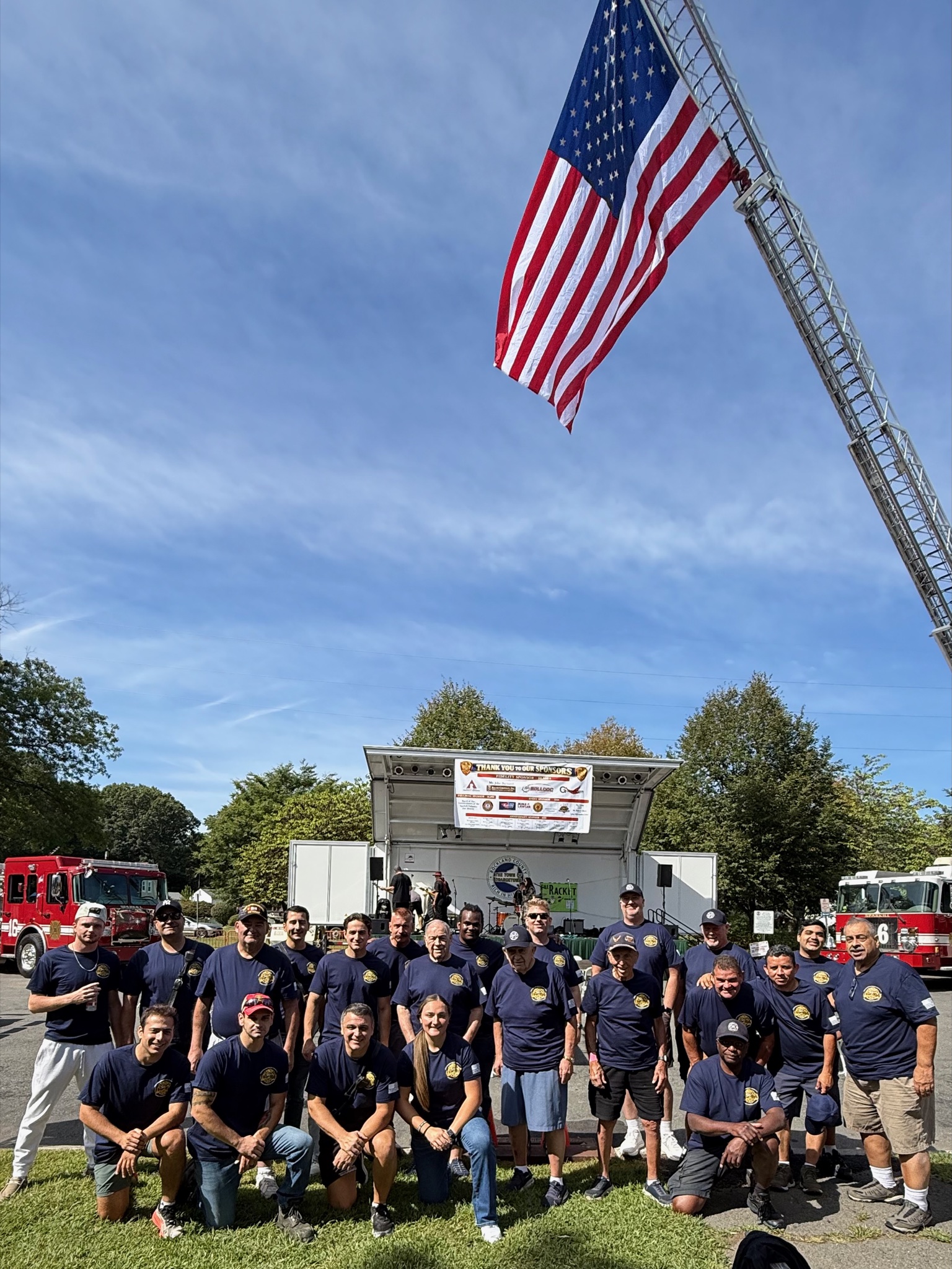 125th Anniversary "Day in the Park" at Depot Square — Full department gathered under the American flag suspended from the aerial ladder